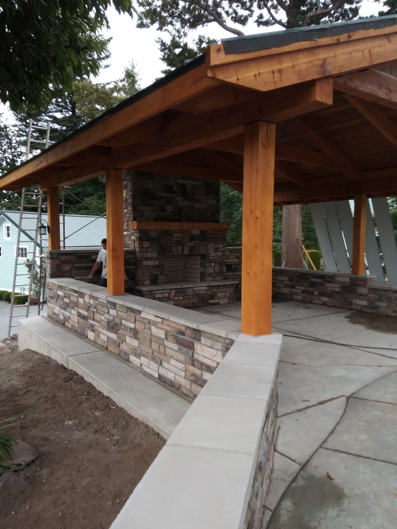 Outdoor stone fireplace within a timber pavilion
